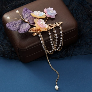 Détail de la pince à cheveux papillon brodée violette avec fleurs et glands de perles