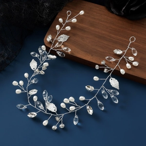 Elegant bridal hair vine with pearls, crystals and silver leaves on dark background