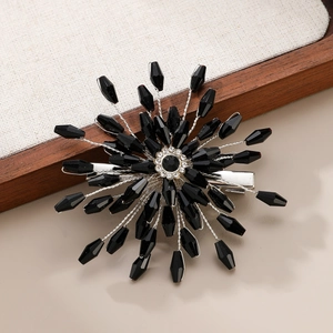 Black crystal sunflower hair clip with bridal rhinestones on a rustic linen tray