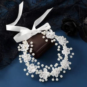Elegant bridal headpiece with white organza flowers and pearls on blue background