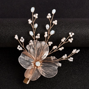 Pince à cheveux de mariée dorée avec perles blanches et bleues sur fond noir