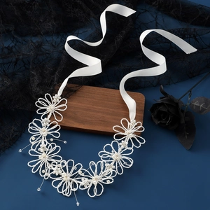 Squisita fascia da sposa con fiori di perle fatti a mano e nastri di raso bianco su fondo scuro