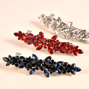Macro shot of rhinestone flower hair clips in red, blue and silver for wedding hair styling