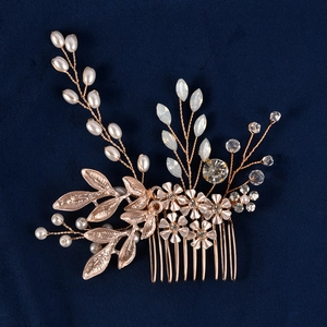 Handmade bridal hair comb with pearls, crystals, and gold leaves on blue velvet background
