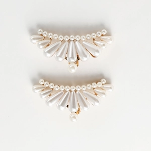 Detailed close-up of fan-shaped white pearl shoe clips with golden metal base
