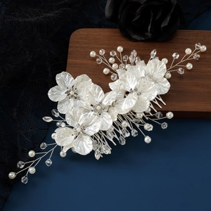 Elegant bridal hair comb with white shell flowers, pearls, and crystals on a silver base