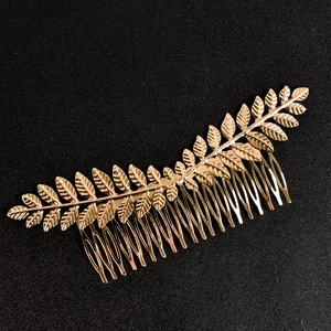 Elegant golden leaf bridal hair comb accessory with textured vein details on black background