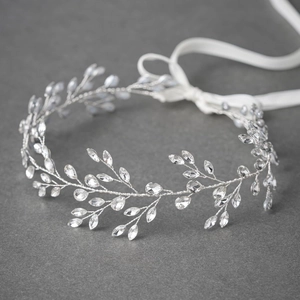 Silver bridal headband with leaf-shaped crystals and silk ribbons on a grey surface