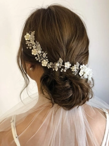 Détail d'un bandeau de mariée argenté avec perles et cristaux sur un chignon bas élégant