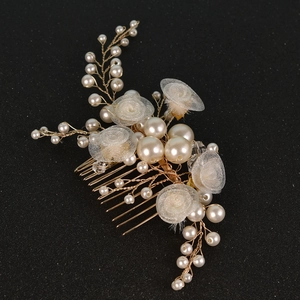 Detail von Brauthaarkamm mit handgefertigten Tüllblumen und Perlen auf goldenem Draht