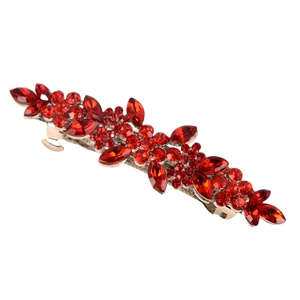 Detailed macro view of silver alloy hair clip with intricate red rhinestones and floral design