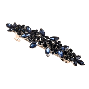 Macro detail of alloy spring clip with dark blue and black rhinestones in floral design
