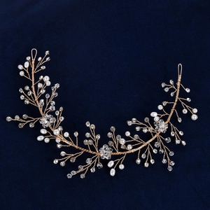 Handmade bridal headband with white pearls and crystals on gold wire against blue velvet