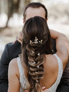 Detail of handcrafted champagne gold leaf hair pins with pearls on elegant bridal hairstyle