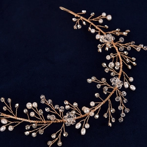 Macro shot of handmade gold wire hair vine with white pearls and clear crystals