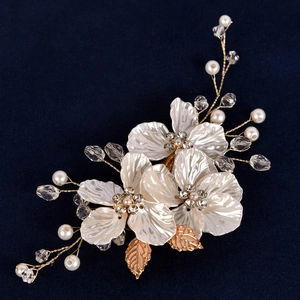 Détail de fleurs de perles blanches avec feuilles dorées et perles de cristal pour mariée