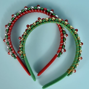 Detail von Weihnachts-Haarreifen mit roten und grünen Perlen und bunten Glocken