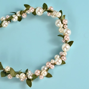Handgefertigter Brautschmuck mit weißen und rosa Perlen, grünen Blättern und Golddraht
