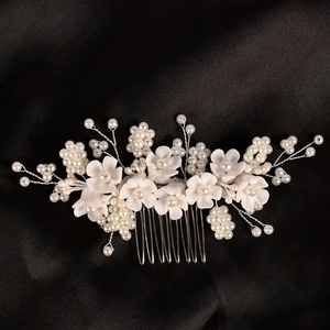 Dettaglio di un pettine da sposa fatto a mano con fiori in resina e perle su filo d'argento