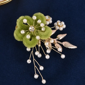 Détail de la barrette florale artisanale avec pétales en velours vert et perles blanches
