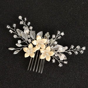 Macro detail of bridal hair comb featuring handmade cream flowers and crystal beads
