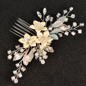 Close-up of handmade bridal hair comb with resin flowers, silver leaves and crystals