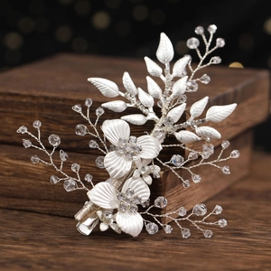 Barrette à fleurs argentées avec cristaux pour mariages sur fond de bois sombre