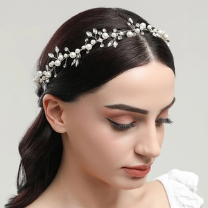 Silver bridal headband with white pearls and sparkling crystals on a graceful model