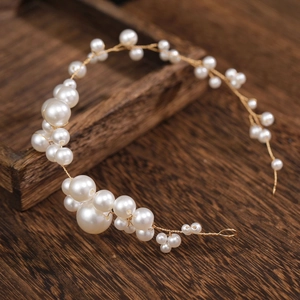 Dettaglio di una fascia da sposa in perle fatta a mano su sfondo in legno vintage