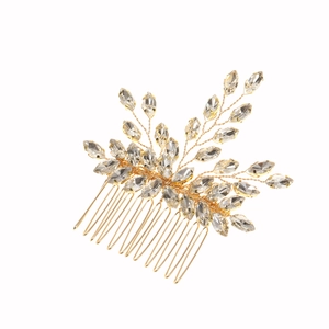 Détail d'un peigne à cheveux doré de mariée avec strass marquise en forme de feuilles