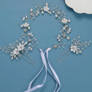 Parure de mariage avec fleurs argentées, perles et cristaux sur fond bleu foncé