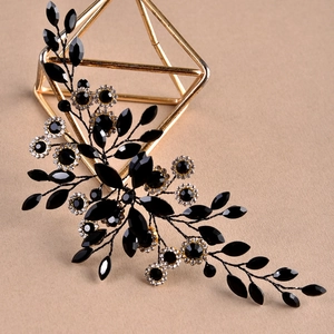 Vintage black crystal marquise leaf hair accessory with rhinestones on a gold geometric stand