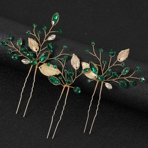 Three-piece gold bridal hair pins with emerald green crystals and hollow metal leaves