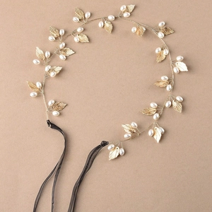 Elegant gold leaf bridal headband with pearls and black ribbon for wedding hairstyles