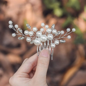 Close-up of handmade bridal hair comb with pearls and marquise rhinestones on silver wire