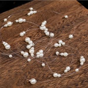 Detail of bridal hair vine with multi-size white pearls on an invisible line for wedding