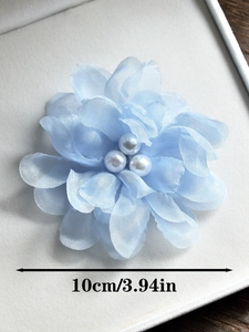 Détail d'une pince à cheveux fleur en mousseline bleu clair de 10cm avec perles au centre