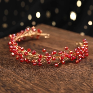 Detail of handmade gold wire hairband with red crystal beads for bridal wedding headpiece
