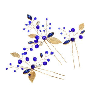 Three-piece gold bridal hair pins with emerald green leaves and blue crystal beads
