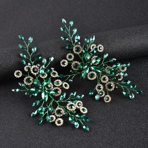 Close-up of emerald green marquise cut crystal hair accessory with leaf design
