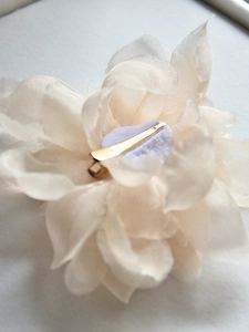 Détail d'une pince à cheveux fleur en mousseline blanche avec attache en métal doré
