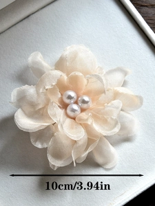 Vue macro détaillée d'une fleur en organza abricot de 10cm avec des perles centrales