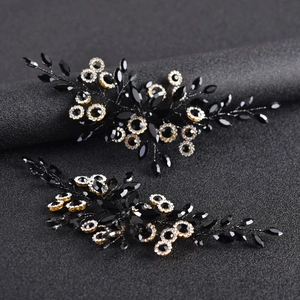 Close-up of black navette crystal hair combs with gold plating and leaf-inspired design