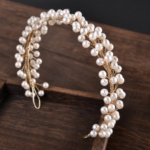 Detailed macro shot of bridal hair accessory with white pearls and gold wire vine
