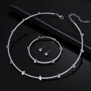 Silver bridal jewelry set with sparkling zircon necklace bracelet and earrings on black surface