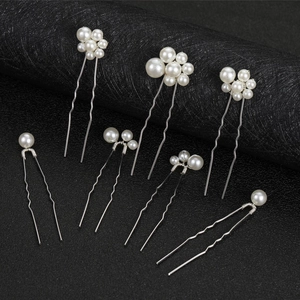 Detail of 7-piece bridal pearl hair pins with U-shaped silver metal base and white beads