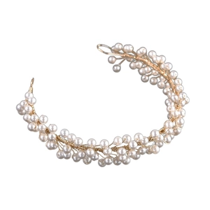 Detailed view of bridal hairband made of white pearls and gold wire on white background