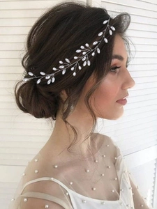 Dettaglio di un tralcio per capelli da sposa in argento con foglie di cristallo indossato