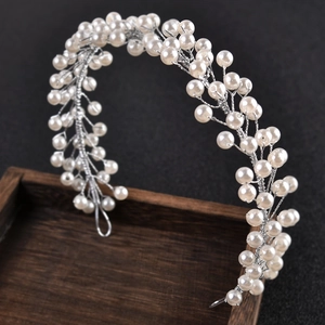 Detail of handmade pearl hairband with woven silver wire floral pattern for bridal wedding