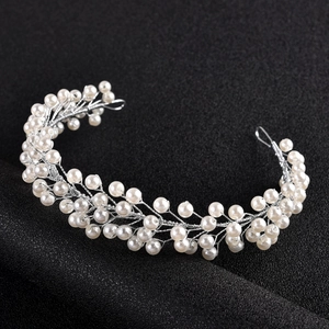 Detail of handmade bridal headband with white pearls and silver wire on black background